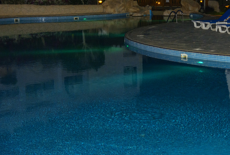 Sharm el-Sheikh, Egypt - March 14, 2018. Beautiful pool with clear blue water and reflection of objects in it at night. Cyrene Grand Hotel.のeditorial素材