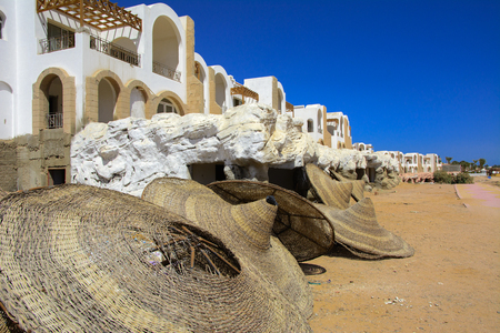 Sharm el-Sheikh, Egypt. Fragments of an unfinished construction and abandoned hotel on the Red Sea on a background of yellow sand and blue sky. Travel rest on a summer day outdoors.の写真素材