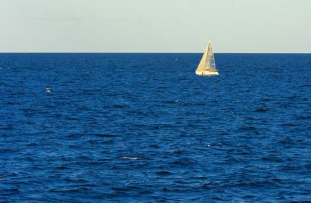 Odessa, Ukraine - August 08, 2018. Gorgeous sailboat on open sea in evening soft sunlight against a blue sky. Concept of summer adventures, holidays, active summer holidays on the Black Sea, Ukraineのeditorial素材