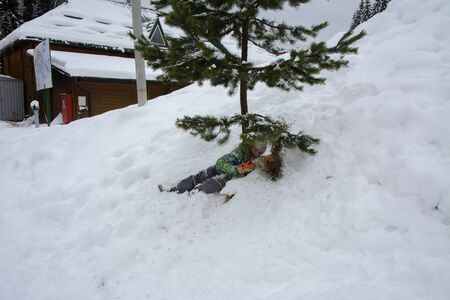 Bukovel, Ukraine - December 26, 2018. One little girl is having fun on a snow slide and enjoying fresh snow on a beautiful winter day in the mountains.のeditorial素材