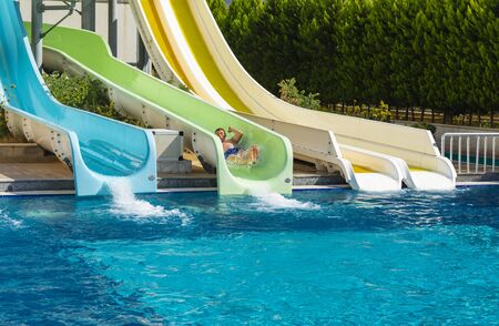 Alanya, Turkey - October 05, 2018. A group of young people are happy to ride the waterslide at the...