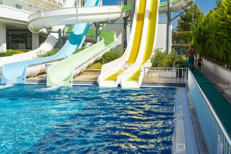 Alanya, Turkey - October 05, 2018. A group of young people are happy to ride the waterslide at the...