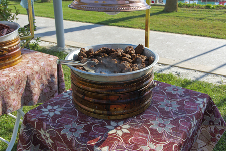 The originally roasted pink tasty veal pieces in an enamel pot against the background of the table. The concept of delicious and healthy food.の写真素材
