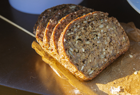 Originally baked delicious rye bread with sunflower seeds inside against the table. The concept of...