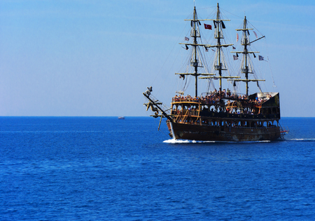 Alanya, Turkey - October 05, 2018. A large sailing ship in a pirate style in the open sea against a blue sky. Photos of the ship from the sea. The concept of summer holidays, sports, tourismのeditorial素材