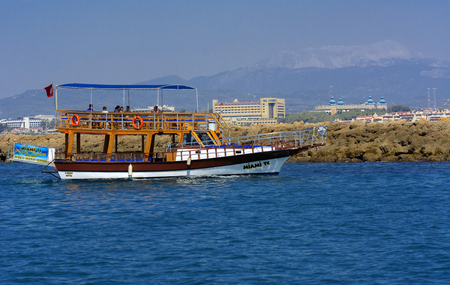 Alanya, Turkey - October 05, 2018. A small sailing ship in a pirate style runs along the coast against a blue sky. Photos of the ship from the sea. The concept of summer holidays, sports, tourismのeditorial素材