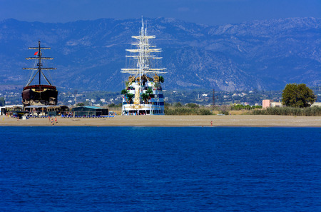 Alanya, Turkey - October 05, 2018. A large sailing ship in a pirate style is moored on the shore for repair against a blue sky. Photos of ship from sea. The concept of summer holidays, sports, tourismのeditorial素材