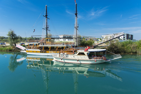 Alanya, Turkey - October 05, 2018. A small sailing ship in a pirate style runs along the coast against a blue sky. Photos of the ship from the sea. The concept of summer holidays, sports, tourismのeditorial素材