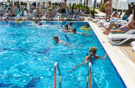 Alanya, Turkey - October 05, 2018. A group of people is engaged in aqua aerobics in the blue clear...