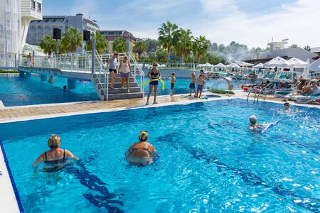 Alanya, Turkey - October 05, 2018. A group of people is engaged in aqua aerobics in the blue clear water of the pool at Kirman Sidera Luxury Spa. Fitness concept, summer vacation, sport, tourismのeditorial素材