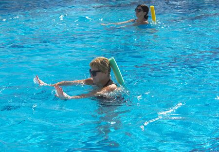Alanya, Turkey - October 05, 2018. A group of people is engaged in aqua aerobics in the blue clear water of the pool at Kirman Sidera Luxury Spa. Fitness concept, summer vacation, sport, tourismのeditorial素材
