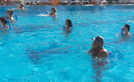 Alanya, Turkey - October 05, 2018. A group of people is engaged in aqua aerobics in the blue clear water of the pool at Kirman Sidera Luxury Spa. Fitness concept, summer vacation, sport, tourismのeditorial素材