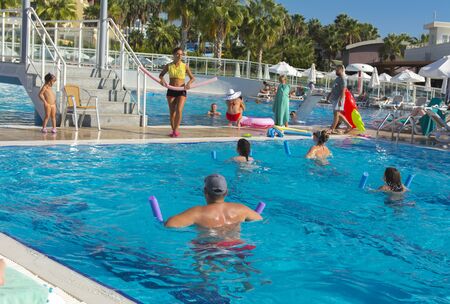 Alanya, Turkey - October 05, 2018. A group of people is engaged in aqua aerobics in the blue clear water of the pool at Kirman Sidera Luxury Spa. Fitness concept, summer vacation, sport, tourismのeditorial素材