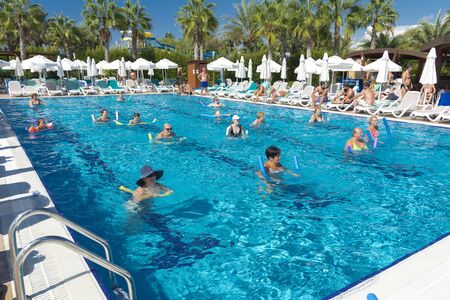 Alanya, Turkey - October 05, 2018. A group of people is engaged in aqua aerobics in the blue clear water of the pool at Kirman Sidera Luxury Spa. Fitness concept, summer vacation, sport, tourismのeditorial素材