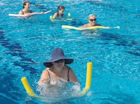 Alanya, Turkey - October 05, 2018. A group of people is engaged in aqua aerobics in the blue clear water of the pool at Kirman Sidera Luxury Spa. Fitness concept, summer vacation, sport, tourismのeditorial素材