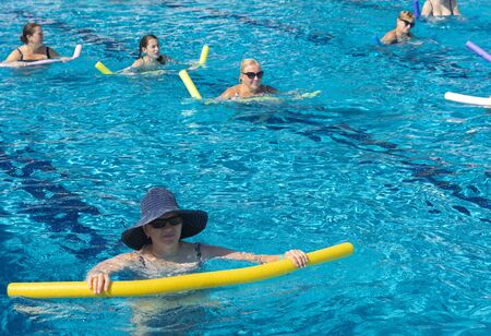 Alanya, Turkey - October 05, 2018. A group of people is engaged in aqua aerobics in the blue clear water of the pool at Kirman Sidera Luxury Spa. Fitness concept, summer vacation, sport, tourismのeditorial素材