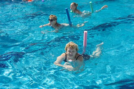Alanya, Turkey - October 05, 2018. A group of people is engaged in aqua aerobics in the blue clear water of the pool at Kirman Sidera Luxury Spa. Fitness concept, summer vacation, sport, tourismのeditorial素材