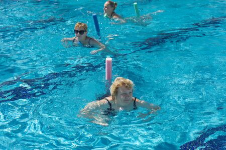 Alanya, Turkey - October 05, 2018. A group of people is engaged in aqua aerobics in the blue clear water of the pool at Kirman Sidera Luxury Spa. Fitness concept, summer vacation, sport, tourismのeditorial素材