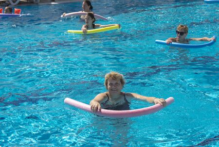 Alanya, Turkey - October 05, 2018. A group of people is engaged in aqua aerobics in the blue clear water of the pool at Kirman Sidera Luxury Spa. Fitness concept, summer vacation, sport, tourismのeditorial素材