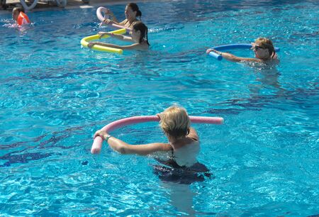 Alanya, Turkey - October 05, 2018. A group of people is engaged in aqua aerobics in the blue clear water of the pool at Kirman Sidera Luxury Spa. Fitness concept, summer vacation, sport, tourismのeditorial素材