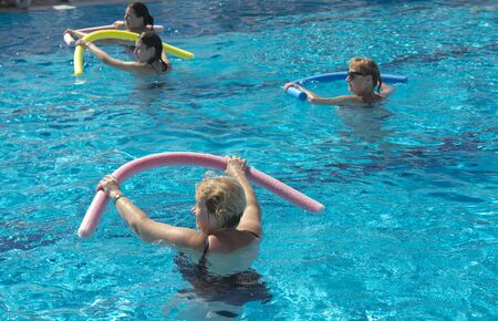 Alanya, Turkey - October 05, 2018. A group of people is engaged in aqua aerobics in the blue clear water of the pool at Kirman Sidera Luxury Spa. Fitness concept, summer vacation, sport, tourismのeditorial素材