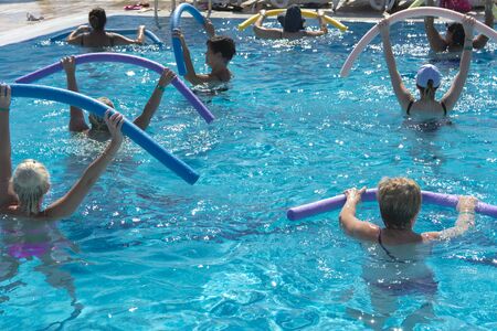 Alanya, Turkey - October 05, 2018. A group of people is engaged in aqua aerobics in the blue clear water of the pool at Kirman Sidera Luxury Spa. Fitness concept, summer vacation, sport, tourismのeditorial素材