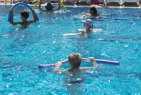 Alanya, Turkey - October 05, 2018. A group of people is engaged in aqua aerobics in the blue clear water of the pool at Kirman Sidera Luxury Spa. Fitness concept, summer vacation, sport, tourismのeditorial素材