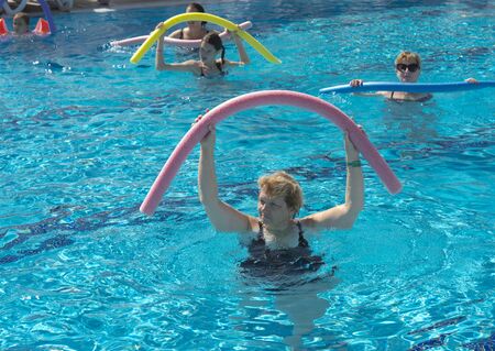 Alanya, Turkey - October 05, 2018. A group of people is engaged in aqua aerobics in the blue clear water of the pool at Kirman Sidera Luxury Spa. Fitness concept, summer vacation, sport, tourismのeditorial素材