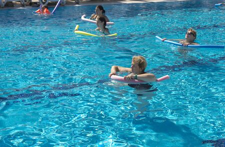 Alanya, Turkey - October 05, 2018. A group of people is engaged in aqua aerobics in the blue clear water of the pool at Kirman Sidera Luxury Spa. Fitness concept, summer vacation, sport, tourismのeditorial素材