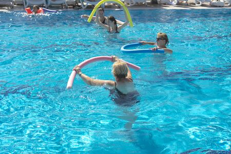 Alanya, Turkey - October 05, 2018. A group of people is engaged in aqua aerobics in the blue clear water of the pool at Kirman Sidera Luxury Spa. Fitness concept, summer vacation, sport, tourismのeditorial素材