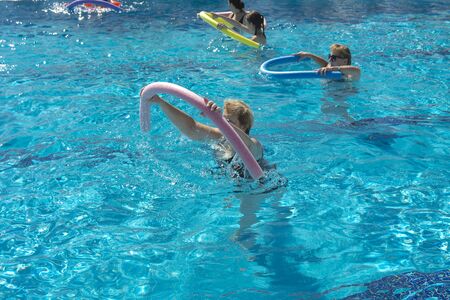 Alanya, Turkey - October 05, 2018. A group of people is engaged in aqua aerobics in the blue clear water of the pool at Kirman Sidera Luxury Spa. Fitness concept, summer vacation, sport, tourismのeditorial素材