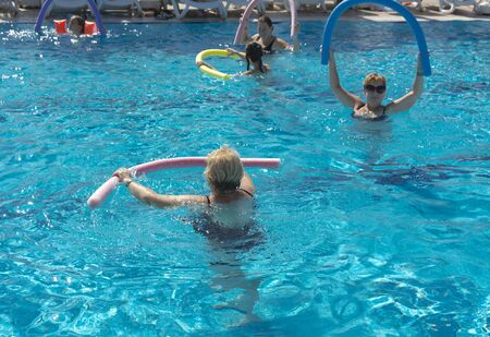 Alanya, Turkey - October 05, 2018. A group of people is engaged in aqua aerobics in the blue clear water of the pool at Kirman Sidera Luxury Spa. Fitness concept, summer vacation, sport, tourismのeditorial素材