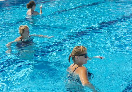 Alanya, Turkey - October 05, 2018. A group of people is engaged in aqua aerobics in the blue clear water of the pool at Kirman Sidera Luxury Spa. Fitness concept, summer vacation, sport, tourismのeditorial素材