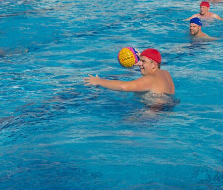 Alanya, Turkey - October 05, 2018. A group of people plays water polo in the blue clear water of the Kirman Sidera Luxury hotel pool. Fitness concept, summer vacation, sport, tourismのeditorial素材