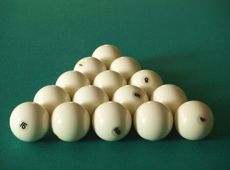 Fifteen white billiard spheres on a green table     
