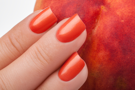 Orange nails on a white background with fruit.の写真素材