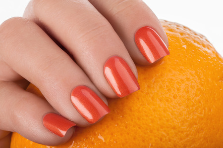 Orange nails on a white background with fruit.の写真素材