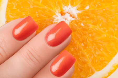 Orange nails on a white background with fruit.の写真素材