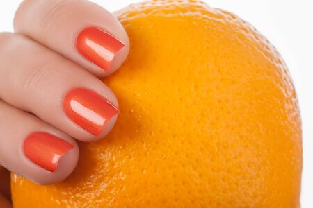 Orange nails on a white background with fruit.の写真素材
