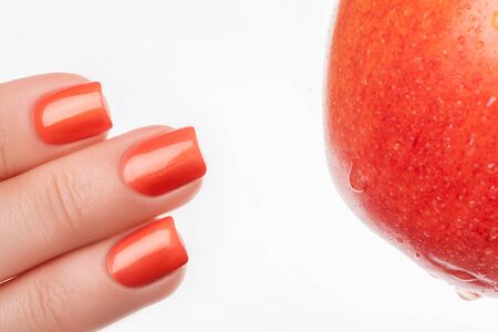 Orange nails on a white background with fruit.の写真素材