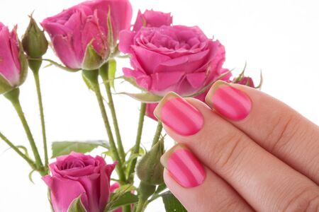 Beautiful pink nails on a white background with flowers.の写真素材