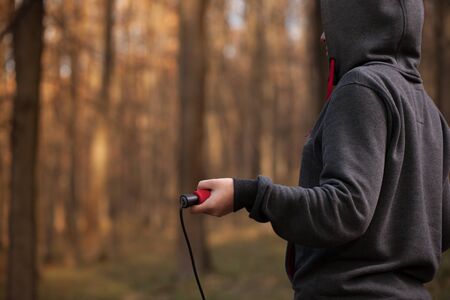 The girl in sportswear is resting in the forest.