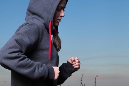 The girl in sportswear is resting in the forest.の写真素材