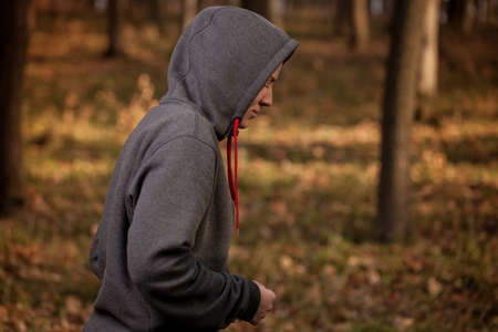 The girl in sportswear is resting in the forest.