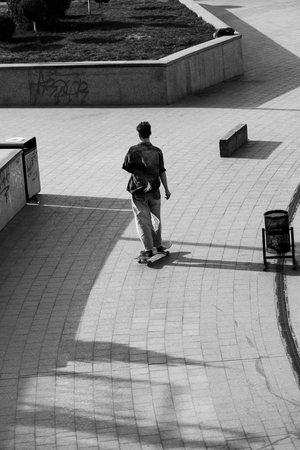 The guys on the skateboard ride on the street.