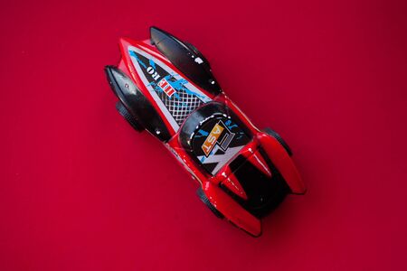 Photo of a toy car on a red background close-up.