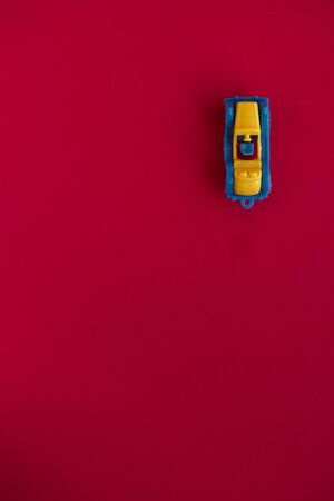 Photo of a toy car on a red background close-up.の写真素材