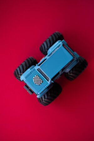 Photo of a toy car on a red background close-up.