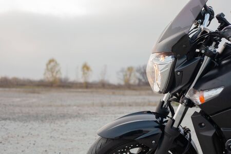 One black motorcycle in the desert in autumn time.