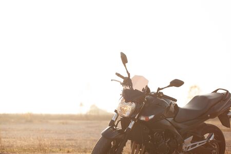 One black motorcycle in the desert in autumn time.の写真素材